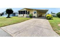 Charming yellow home featuring a spacious carport and well-manicured lawn at 1811 Sherwood Hill Dr, Lakeland, FL 33810