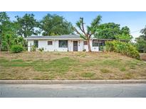 Charming single-story home with a white exterior, well-maintained lawn, and mature trees, creating an inviting curb appeal at 1830 Casco, Lakeland, FL 33801
