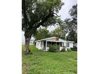 Front exterior of a house with an overgrown front yard and large tree at 1938 Lavon St, Lakeland, FL 33805