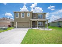 Charming two-story home with a well-manicured lawn and two car garage at 2062 Blue Highlands Dr, Lakeland, FL 33811