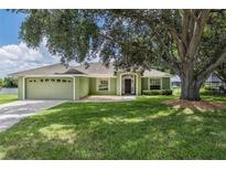 Charming single-story home boasts a well-maintained lawn, mature shade tree, and a welcoming two-car garage at 2714 Highlands Vue Pkwy, Lakeland, FL 33813