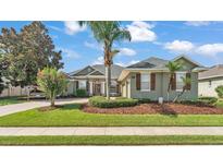 Charming one-story home with a lush lawn, mature trees, and well-manicured landscaping at 2817 High Winds Ln, Lakeland, FL 33813
