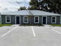 Charming duplex featuring a durable metal roof, dark blue doors, and well-maintained landscaping at 508 & 510 2Nd Sw St, Fort Meade, FL 33841