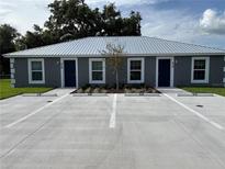 View of a two-unit residential building featuring a metal roof and reserved parking spots at 514 & 516 2Nd Sw St, Fort Meade, FL 33841