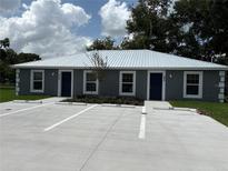 New two-unit building featuring a metal roof, marked parking, and fresh landscaping at 520 & 522 2Nd Sw St, Fort Meade, FL 33841