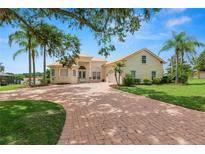 Beautiful single-Gathering home with a circular driveway, palm trees, and lush green lawn at 6217 Ashley Dr, Lakeland, FL 33813