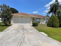 Charming single-story home with a well-manicured lawn, two-car garage, and concrete driveway at 624 Brockton Dr, Kissimmee, FL 34758
