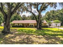 Charming home with a well-manicured lawn and beautiful mature shade trees at 6920 Newman E Cir, Lakeland, FL 33811