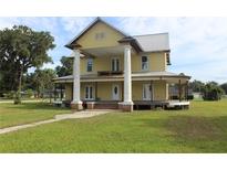 Charming two-story home with a metal roof and large pillars on an expansive green lawn at 701 1St Ne St, Fort Meade, FL 33841
