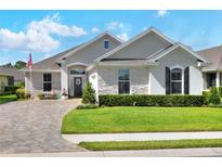 Beautiful single-story home with stone accents, manicured lawn, and a brick-paved driveway in a desirable community at 7770 Lake James Blvd, Lakeland, FL 33810