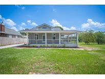 Charming home with a screened-in porch, a well-manicured lawn, and lovely landscaping at 783 E Central Ave, Eagle Lake, FL 33839