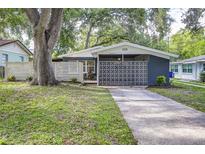 Charming single-story home with a modern exterior design, mature trees, and inviting curb appeal at 906 E Lowell St, Lakeland, FL 33805