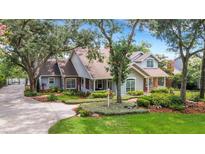 Charming two-story home featuring mature trees, a landscaped yard, and a welcoming front porch at 1018 E Highland Dr, Lakeland, FL 33813