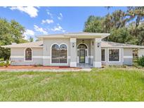 Charming home with a well-manicured lawn, arched windows, and a covered entryway at 1102 Berkley Ln, Winter Haven, FL 33880