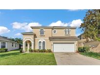 Charming two-story home with a well-manicured lawn and a two car garage at 141 Minniehaha Cir, Haines City, FL 33844