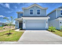 Charming two-story home features a two-car garage, manicured lawn, and craftsman style elevation at 1497 Leamington Ln, Winter Haven, FL 33884