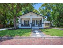 Charming single-story home featuring a welcoming front porch, classic design, and lush landscaping at 213 Cannon St, Lakeland, FL 33803