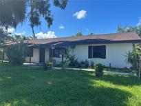 Charming single-story home with a front yard and some landscaping on a sunny day at 2250 Maple Hill Dr, Lakeland, FL 33811