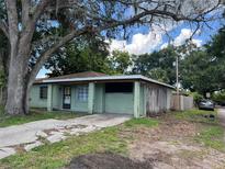 Single-story home featuring light-green exterior, driveway, and mature trees at 2921 Galaxy Ln, Lakeland, FL 33801