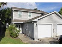 Charming two-story home with a well-manicured lawn, two-car garage, and welcoming front entrance at 301 Orange Blossom Dr, Winter Haven, FL 33880