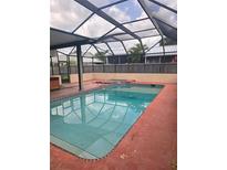 Covered backyard pool with patio, fence, and ladder for summer enjoyment at 341 Sterling Dr, Winter Haven, FL 33884
