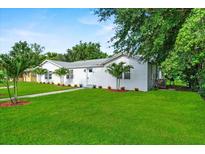 Charming single-story home with a well-manicured lawn, fresh landscaping, and mature trees on a beautiful sunny day at 405 S 7Th Ave, Bartow, FL 33830