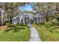 Charming single-story home featuring a turret, inviting entryway, and mature landscaping at 5722 Antler Trl, Lakeland, FL 33811