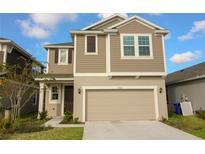 Two-story home featuring a two-car garage, neutral siding, and a well-maintained front lawn at 6524 Great Bear Drive Blvd, Lakeland, FL 33805