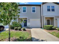 Charming two-story townhome with a one-car garage and a well-maintained front yard at 943 Grandin St, Davenport, FL 33837