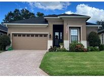 Well-maintained single Gathering home with a brick driveway, tidy landscaping, and a two car garage at 961 Christina Chase Dr, Lakeland, FL 33813