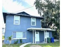 Two-story home featuring a front porch, a well-maintained yard, and a large tree at 121 F Sw Ave, Winter Haven, FL 33880