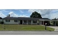 Charming one-story home featuring a well-maintained front yard and convenient carport at 1216 W Lake Buckeye Dr, Winter Haven, FL 33881