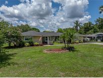 Charming single-story home featuring a well-manicured lawn and beautiful landscaping at 1232 Fairlee St, Lakeland, FL 33813