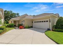 Charming single-story home featuring a tile roof, attached two-car garage, and lush landscaping at 1707 Laurel Glen Pl, Lakeland, FL 33803