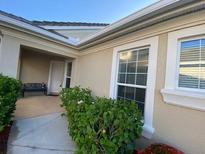 Inviting front entrance with a bench and walkway lined with green shrubs and flowering plants at 1707 Laurel Glen Pl, Lakeland, FL 33803