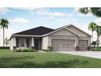Charming single-Gathering home features a three-car garage, gray facade, and lush landscaping, creating inviting curb appeal at 2228 Summerlake Ct, Auburndale, FL 33823