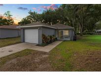 Charming single-story home with a one-car garage and a well-maintained front yard at sunset at 3015 Thornhill Rd, Winter Haven, FL 33880
