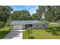 Charming single-story home featuring a well-maintained lawn, landscaping, and attached garage at 3560 Sandpiper Ln, Mulberry, FL 33860