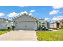 Charming single-story home featuring a gray exterior, well-manicured lawn, and an attached two-car garage at 3739 Peregrine Way, Lakeland, FL 33811