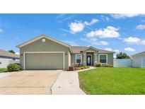 Charming single-story home with a well-manicured lawn, inviting entryway, and a spacious two-car garage at 577 Majestic Gardens Blvd, Winter Haven, FL 33880