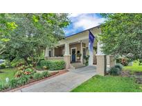 Charming home showcasing a lovely landscaped front yard, covered porch, and inviting blue front door at 608 Finney St, Lakeland, FL 33803