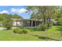 Charming single-story home with a covered carport and screened porch, surrounded by lush landscaping at 640 Forrest Dr, Bartow, FL 33830