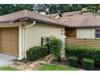 Cozy home exterior with a one-car garage, brick walkway, and neatly trimmed bushes at 925 Fenton Ln # 18, Lakeland, FL 33809