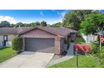 Charming home featuring a brick facade, well-maintained landscaping, and a two-car garage at 1523 Mariner Rd, Lakeland, FL 33803