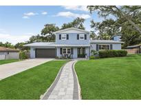 Charming two-story home with beautiful landscaping and a walkway to the front door at 1210 Heidi S Ln, Lakeland, FL 33813