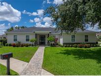 Charming single-story home featuring a landscaped yard with brick walkway at 128 Melissa Trl, Auburndale, FL 33823
