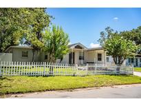 Charming home featuring a white picket fence and mature trees enhancing the curb appeal at 1720 Park Dr, Lakeland, FL 33803