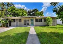 Charming single-story home with a well-maintained lawn and a bright blue front door at 215 W Valencia St, Lakeland, FL 33805
