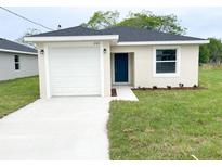 Charming single-story home with a well-manicured lawn, a driveway, and a blue front door at 2521 Sunset Dr, Winter Haven, FL 33881
