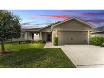 Charming single-story home featuring a manicured lawn, two-car garage, and covered entryway at 4143 Red Fern Ln, Lakeland, FL 33811